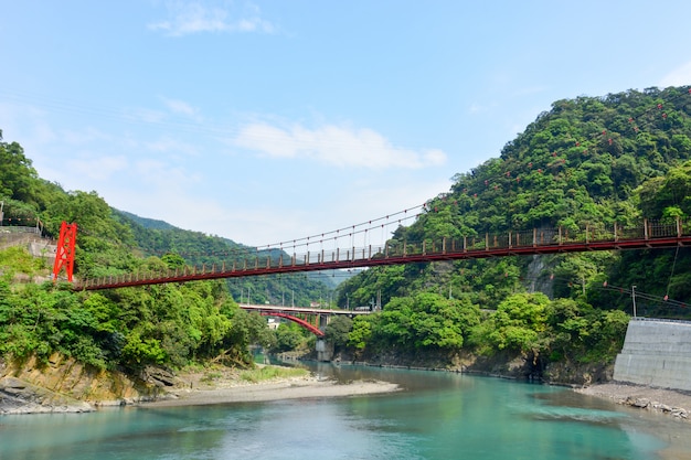 Ponte sospeso rosso sopra il fiume