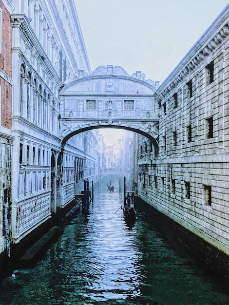 Ponte sul canale in una Venezia nebbiosa