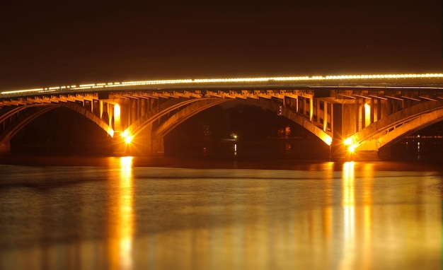 Ponte sul fiume con riflesso di luci nell'acqua