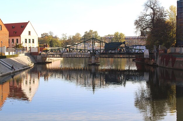 Ponte sul fiume da edifici contro il cielo