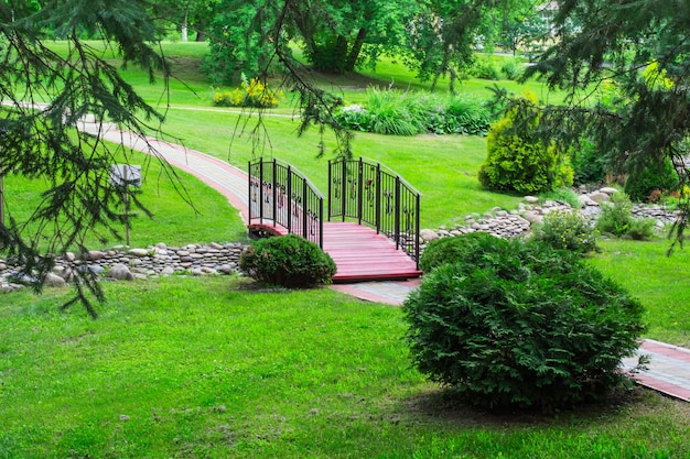 Ponte sul ruscello nel parco. Concetto di progettazione del paesaggio.