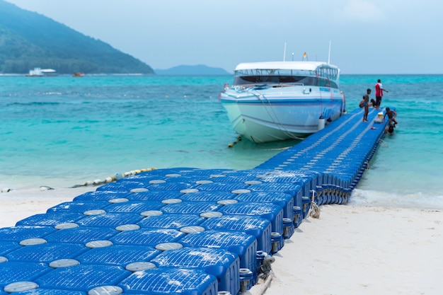 Pontile galleggiante blu in plastica HDPE. sul mare blu esotico con spiaggia di sabbia bianca contro montagne tropicali.