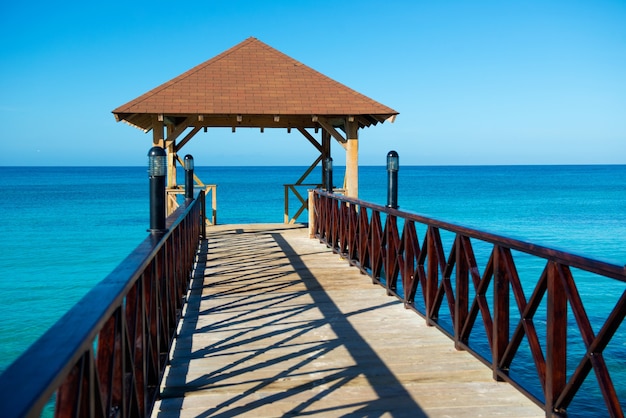 Pontile in legno con tettoia e con recinzione che si protende verso il mare