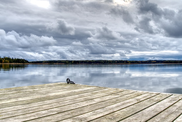 Pontile in legno per piccole imbarcazioni, vista laghetto e bel cielo