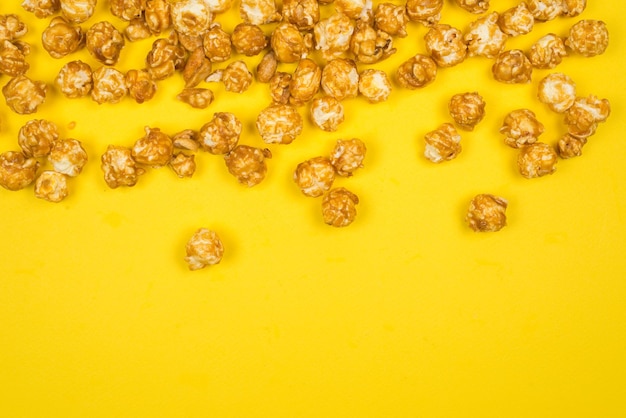 Pop corn caramello su sfondo giallo Spazio di copia