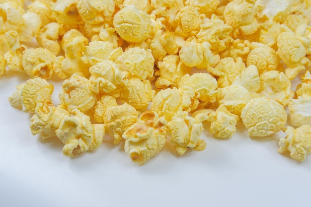 Popcorn al burro sparsi su uno sfondo bianco