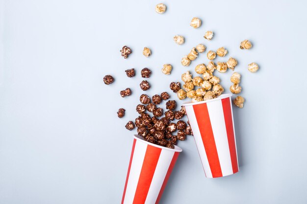 Popcorn al cioccolato caramellato dolce in tazza bianca rossa a strisce di carta