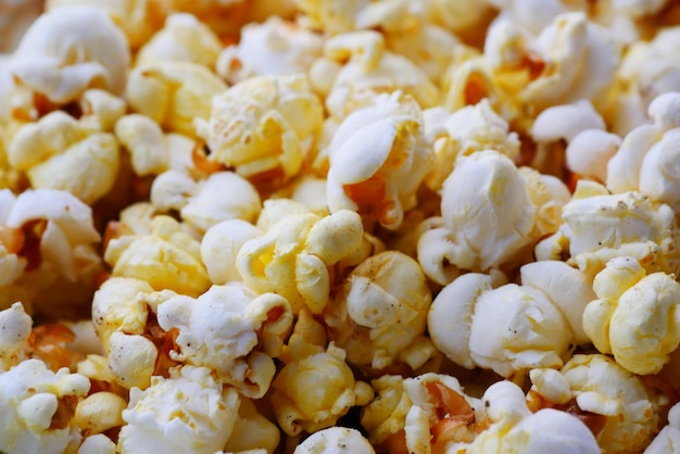 popcorn che fuoriesce da un contenitore su sfondo rosso