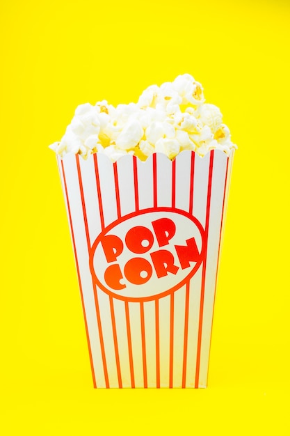 Popcorn classico del cinema della scatola sulla parete gialla