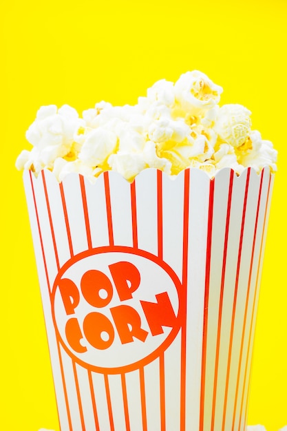 Popcorn classico del cinema della scatola sulla parete gialla