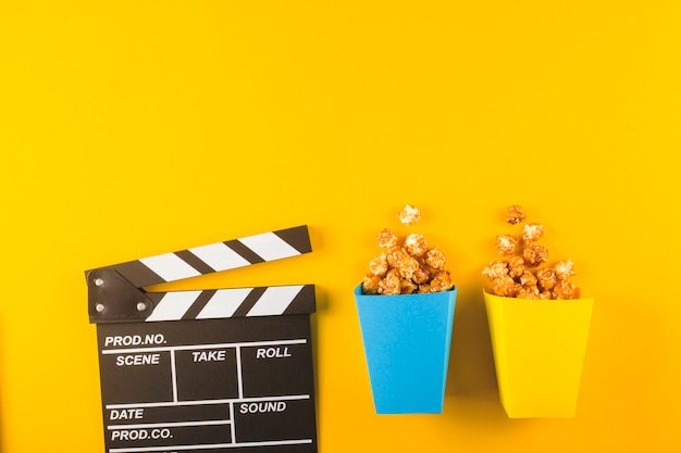 Popcorn e Ciak sul tavolo giallo. Vista dall'alto