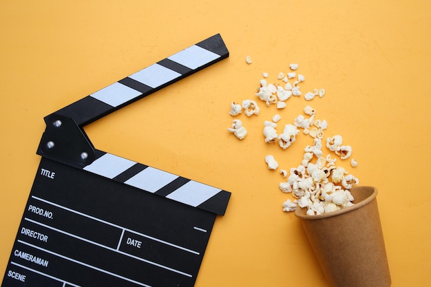 Popcorn e clapperboard su sfondo giallo