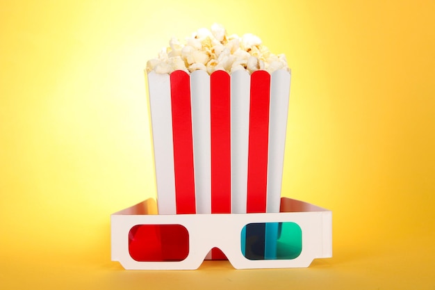Popcorn e occhiali 3D su sfondo giallo