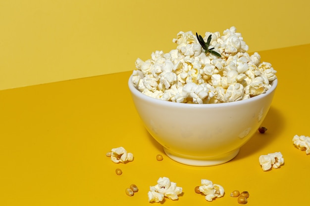 Popcorn fatti in casa sul tavolo colorato con luce ad alto contrasto. Concetto di snack