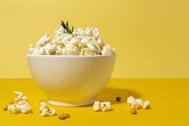 Popcorn fatti in casa sul tavolo colorato con luce ad alto contrasto. Concetto di snack