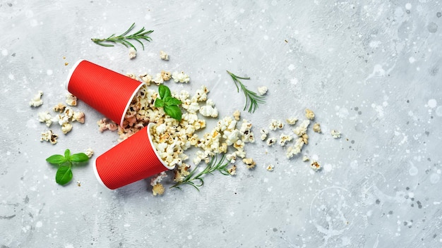 Popcorn in bicchieri di carta Spuntini per guardare film Su uno sfondo di pietra grigia Vista dall'alto