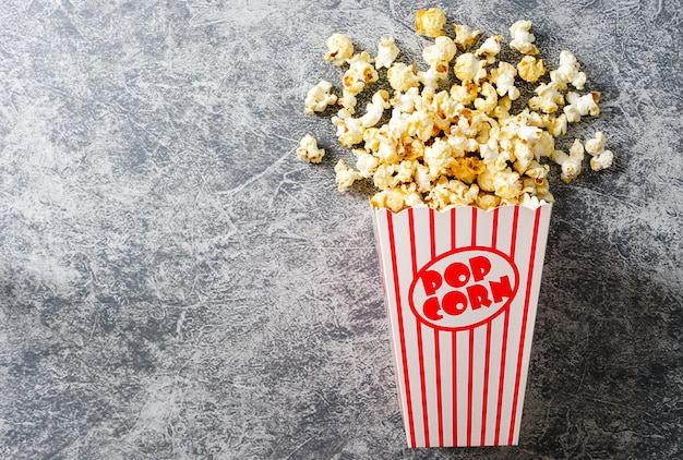 Popcorn in cartone rosso e bianco su sfondo Loft Vista dall'alto piatta