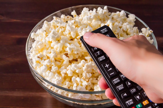 Popcorn in ciotola di vetro e telecomando