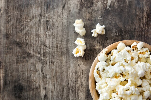 Popcorn in ciotola sulla tavola di legno, vista superiore