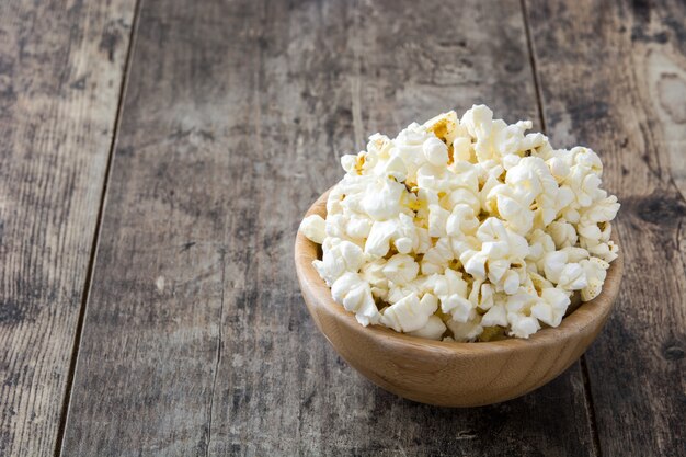 Popcorn in ciotola sullo spazio di legno della copia della tavola