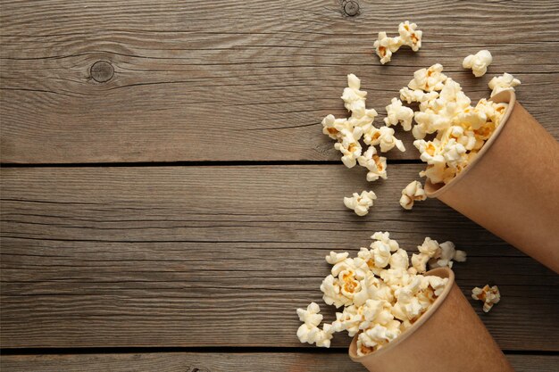 Popcorn in tazze marroni. Due tazze di popcorn su fondo di legno grigio. Popcorn dolci. Vista dall'alto