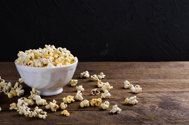 Popcorn salato all'aria Una ciotola di popcorn su una tavola di legno Popcorn salato sulla tavola di legno.