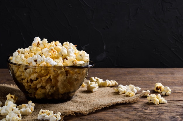 Popcorn salato all'aria Una ciotola di popcorn su una tavola di legno Popcorn salato sulla tavola di legno.