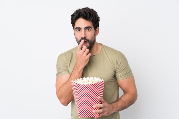 popcorn uomo mangia mentre si guarda un film sul muro isolato