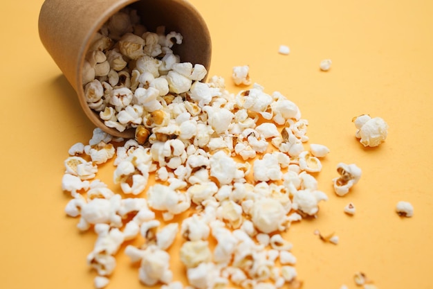 Popcorn versato su uno sfondo giallo Cinema film e concetto di intrattenimento