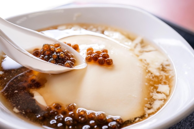 Popolare Taiwan gourmet Dessert di tapioca palla di perle bolla mista cagliata di fagioli budino di tofu douhua dou hua in ciotola bianca close up lifestyle