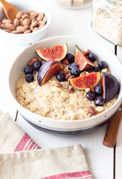 Porridge di avena con fichi mirtilli mandorle e miele Alimentazione sana Cibo vegetariano Colazione