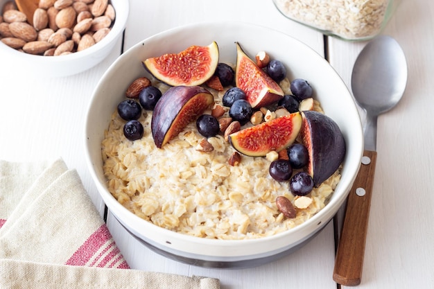 Porridge di avena con fichi mirtilli mandorle e miele Alimentazione sana Cibo vegetariano Colazione