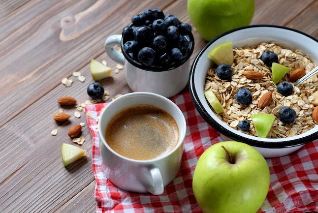 Porridge di farina d'avena caffè bacche di mele e noci su un tavolo di legno Vista dall'alto