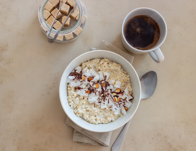 Porridge di farina d'avena con mandorle, cocco e cioccolato. Mangiare sano. Cibo vegetariano. Prima colazione. Dieta.