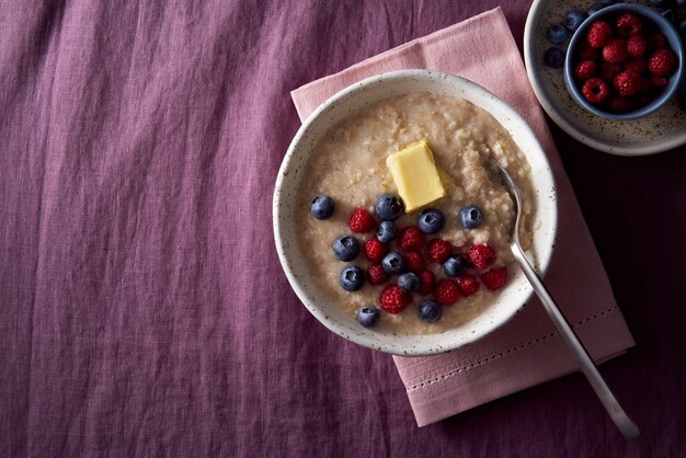 Porridge di farina d'avena con mirtillo mirtillo colazione in una ciotola bianca