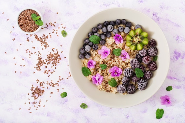 Porridge di farina d&#39;avena gustoso e sano con frutta, bacche e semi di lino. Colazione salutare.