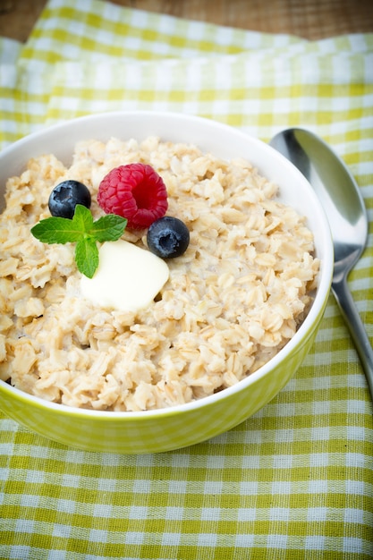 Porridge di farina d'avena in una ciotola con lamponi e more.