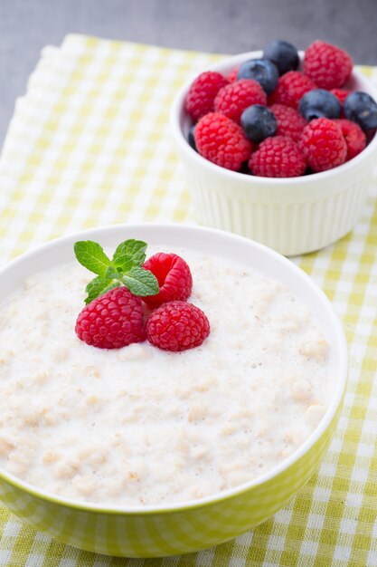 Porridge di farina d'avena in una ciotola con lamponi e more.