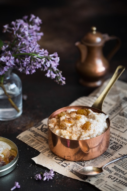 Porridge di farina d'avena in una pentola e fiori lilla