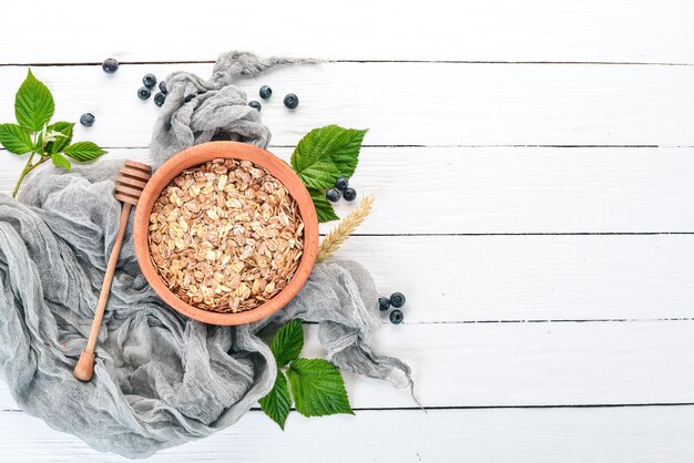 Porridge di farina d'avena secca in un piatto Colazione su uno sfondo di legno Vista dall'alto Spazio libero per il testo