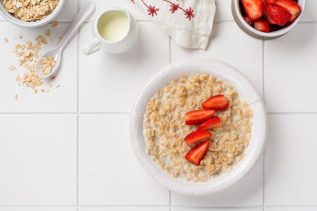 Porridge di farina d'avena semplice con fragole in un piatto bianco su un tovagliolo di lino