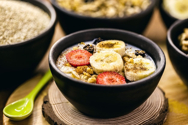 Porridge di quinoa vegano, fragole, banane, arachidi e cannella cosparsa. Dessert senza lattosio senza latte