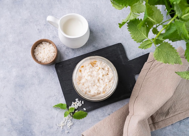 Porridge di riso con latte di cocco in ciotola su sfondo blu Concetto di alimento nutriente e soddisfacente