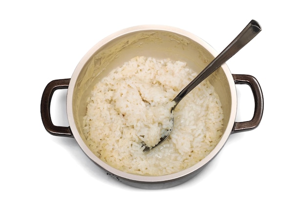 Porridge di riso e cucchiaio in padella isolare