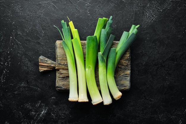 Porro verde crudo su sfondo nero Verdure per un'alimentazione sana Vista dall'alto Spazio per la copia gratuito