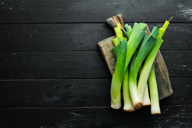 Porro verde crudo su sfondo nero Verdure per un'alimentazione sana Vista dall'alto Spazio per la copia gratuito