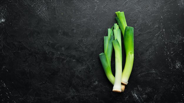 Porro verde crudo su sfondo nero Verdure per un'alimentazione sana Vista dall'alto Spazio per la copia gratuito