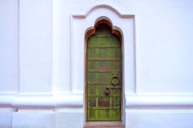 Porta d'annata sul muro bianco