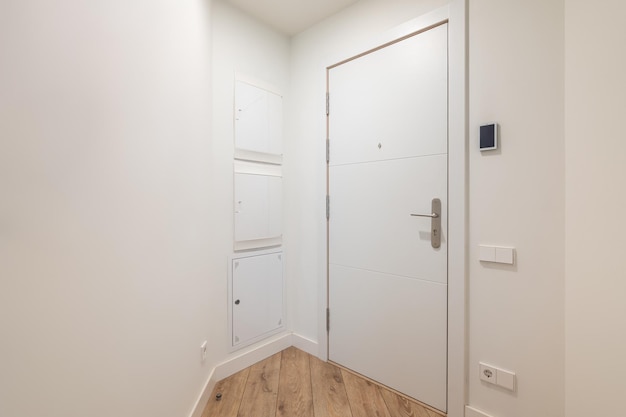 Porta d'ingresso in legno bianca chiusa all'interno dell'appartamento che conduce all'appartamento di strada con pareti bianche