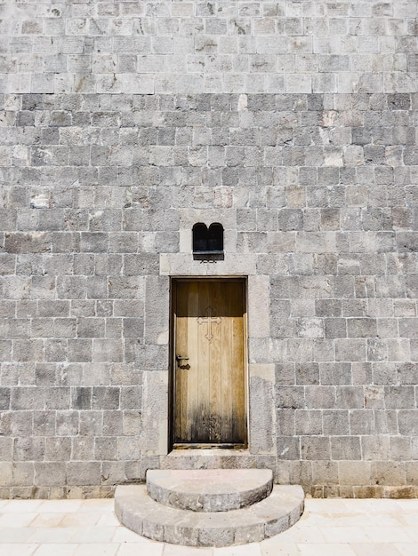 Porta di legno sulla facciata in pietra della chiesa della santissima trinità budva montenegro